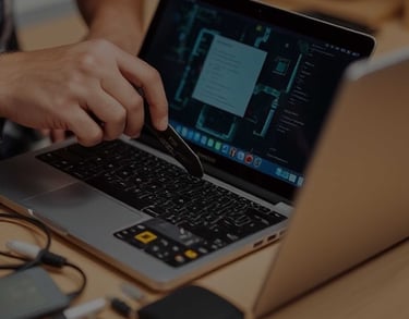 a person is using a laptop computer and a pen