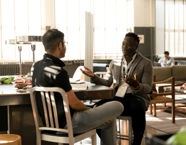 two men sitting at a table with a table with a table cloth