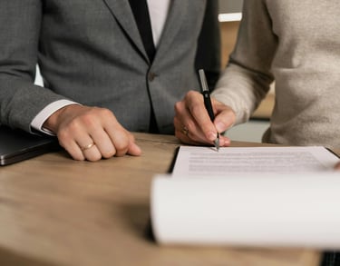 a man and woman sitting at a desk with papers and papers
