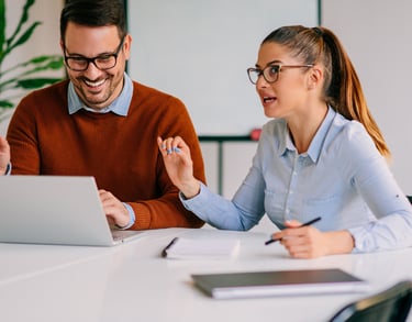 Ein Mann und eine Frau, die an einem Tisch eine Beratung haben