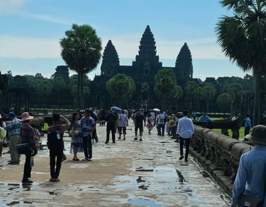 Visitors walking along the main stone pathway to Angkor Wat in Cambodia on a clear day