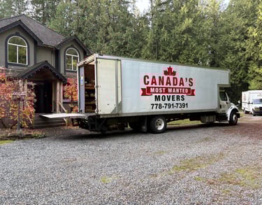 Canada’s Most Wanted Movers truck parked at a forest-side home in the Lower Mainland during a residential move.