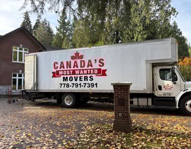 Canada’s Most Wanted Movers truck positioned outside a large brick home for a residential move in Langley..