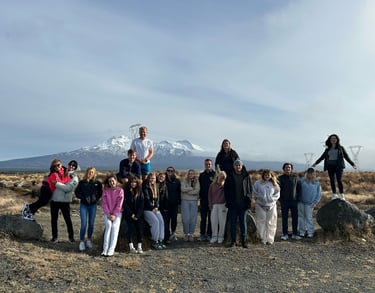 a tour group standing in front of a mountain in the north island of new zealand
