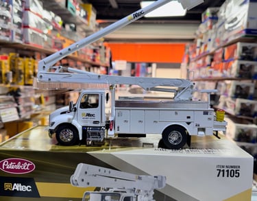 es una grua de auto de colección a escala color blanca que esta sobre su caja en un fonde de tienda 
