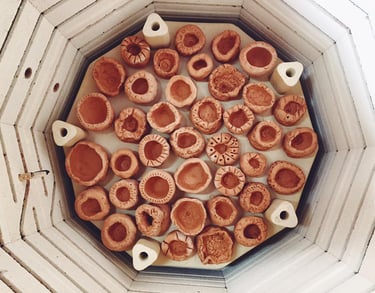 a set of pinch pot clay creations in a kiln