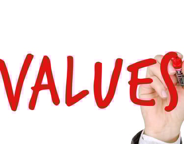 hand writing the word "values" with a marker symbolizing augusta precious metals blog post about their values