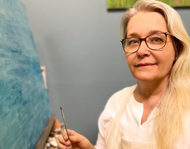 Else Norking, artista plástica, segura pincel enquanto trabalha em tela azul em seu ateliê.