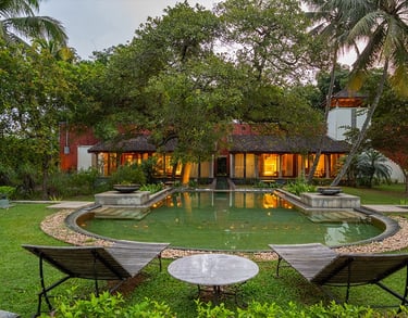 Lakeside luxury villa in Kerala, featuring a serene garden, traditional architecture.