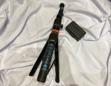 Black Cohhee tripod with a microphone beside it.