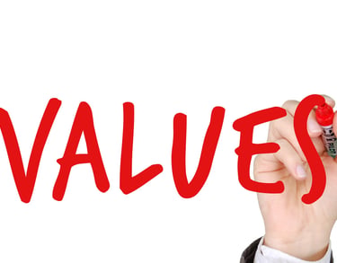 hand writing the word "values" with a marker symbolizing augusta precious metals blog post about their values