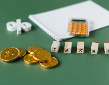 gold coins, calculator and word taxes show gold ira taxes and learning potential tax benefits