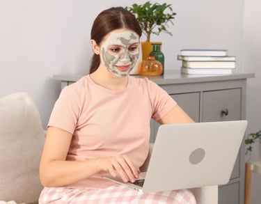 Una mujer lleva una mascarilla facial mientras usa su ordenador portátil y se relaja