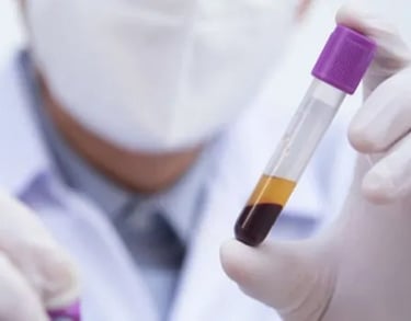 a doctor with a mask holding a test tube of blood with gloved hands