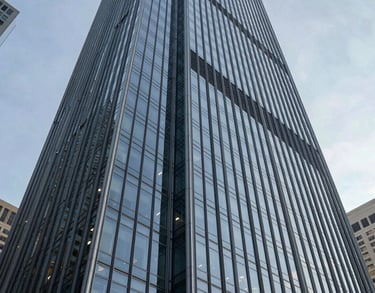 A sleek, low-angle photograph of a modern glass skyscraper in a North American business district, representing the strength and authority of the Foundation.