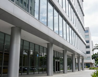 A clean, bright corridor in a corporate Brazilian legal building. Modern architecture with floor-to-ceiling glass and light gray steel elements. Sophisticated and transparent.