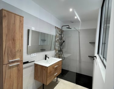 Salle de bain : meuble bois, douche à l'italienne et grand miroir minimaliste.