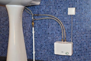 Chauffe-eau électrique sans réservoir installé sous un lavabo sur colonne à Yaoundé