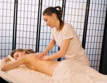 Masajista profesional realizando un masaje profundo en la espalda a un cliente en un spa.