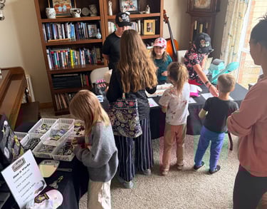 people at hat making station, kids and adults