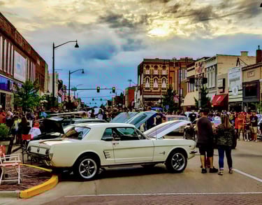 Vintage Ford Mustang at a crowded outdoor classic car show on a historic downtown streator IL