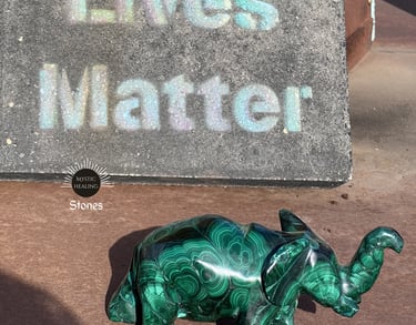 A green malachite elephant crystal figurine displaying natural banding patterns.