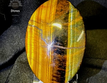 Polished oval tiger's eye healing crystal with golden chatoyant bands on a clear stand.