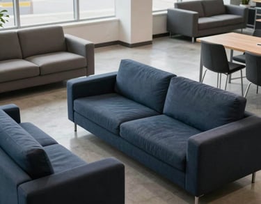 A high-angle photo of a modern office lounge area in a logistics company, featuring navy and slate furniture, clean lines, and natural lighting, North American / US.