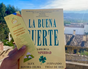 Libro La Buena Suerte con marcapáginas de diseño local y paisaje de montaña de fondo
