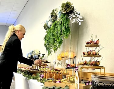 Proveedor de catering profesional que organiza una mesa buffet de lujo con aperitivos  y decoración.