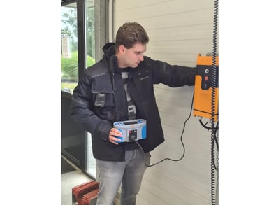Inspecteur test elektrische laadinstallatie met meetapparatuur in industriële omgeving