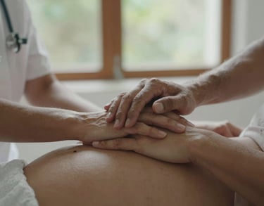 A close-up photograph of a professional South American therapist's hands gently holding a pregnant woman's hands, soft natural light through a window, conveying trust and connection.