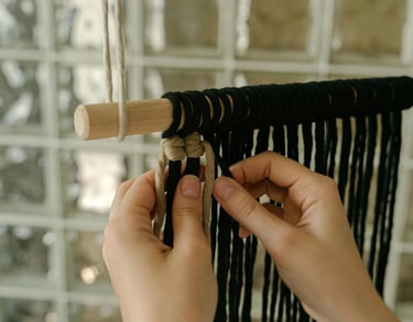 tejiendo macramé con un palo para colgar 
