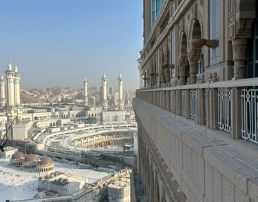 High-angle view of Masjid al-Haram and the Kaaba in Mecca from a hotel balcony building.