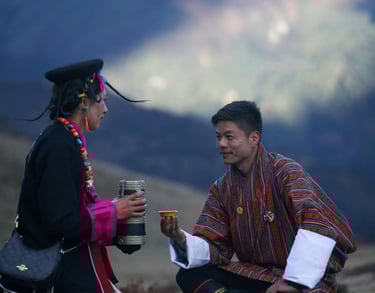 Layap-women-in-Bhutan-with-a-traditional-gesture-of-welcoming-a-guest-serving-local-wine-ara