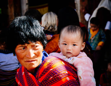 typical-bhutanese-women-carrying-her-new-born-at-her-back-held-with-traditional-hand-woven-fabrics