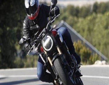 a man riding a motorcycle on a road