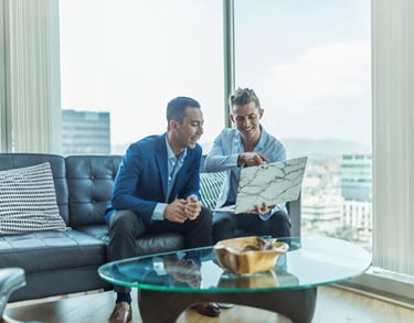 two men sitting on a couch in a living room