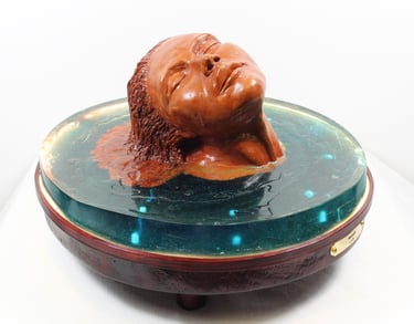 Sculpture de l'artiste Lode intitulée Naïade, représentant le buste d'une femme dans l'eau.  