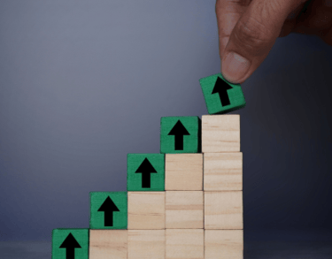 a person's hand is placing a block of wood blocks on top of a