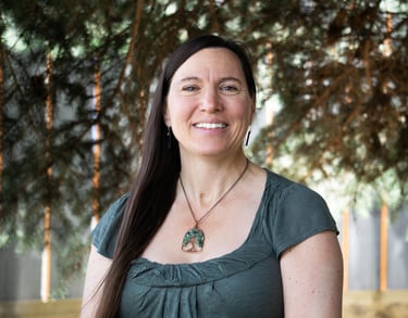 a woman with long hair in a green shirt smiling