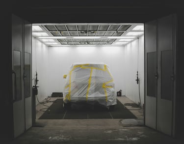 vehicle in a paint bay at a body shop, getting new auto paint repair