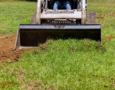 skid-steer-clearing-dirt-with-bucket-attachment.jpg