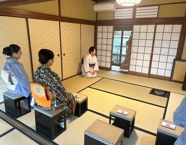 Woman in a kimono seated in a traditional Japanese tea room