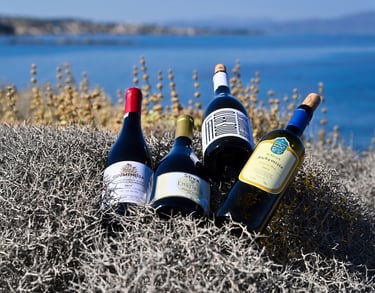 four greek bottles of wine on a thyme area