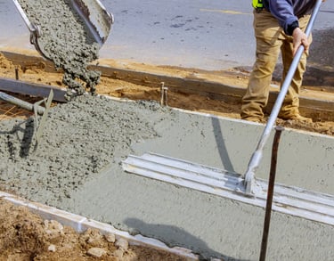 a man is pouring concrete into a concrete slab