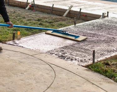 a man is using a blue broom to clean the concrete