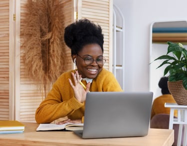 a woman sitting at a table with a laptop computer