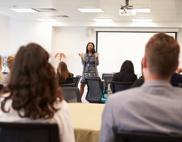 a woman in a business suit is standing in front of a presentation