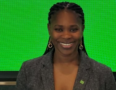 a woman in a gray jacket and earrings